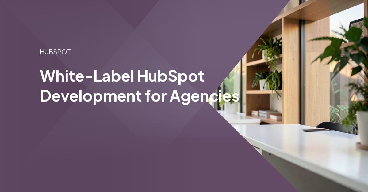 A developer builds a HubSpot theme on a laptop while an agency's own logo displays on screen, representing white-label development delivered under another brand.