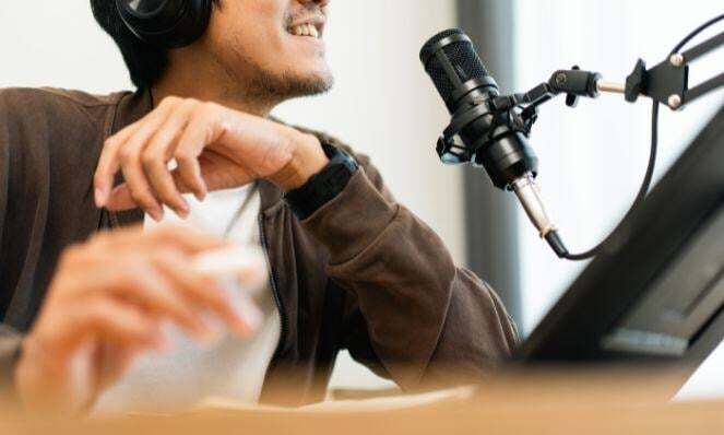 Man smiling in front of a microphone.