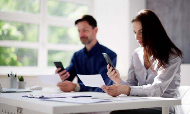 Two people checking alerts on their phones.