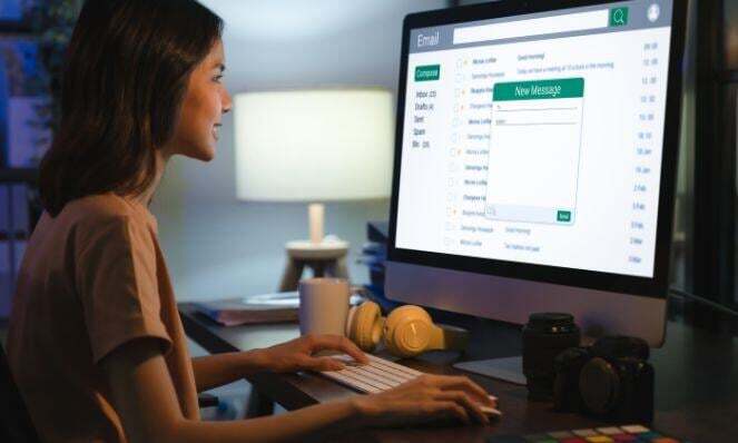 Woman working on her PC while typing email.