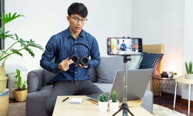 Male content creator creating an instructional video of himself using his phone on a tripod.