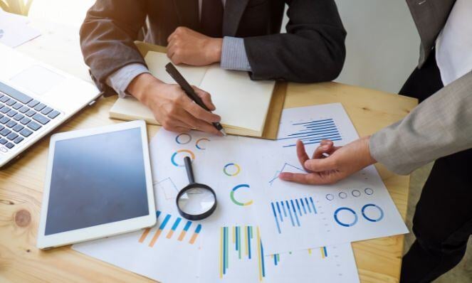Workmates working on an audit with graphs on papers.
