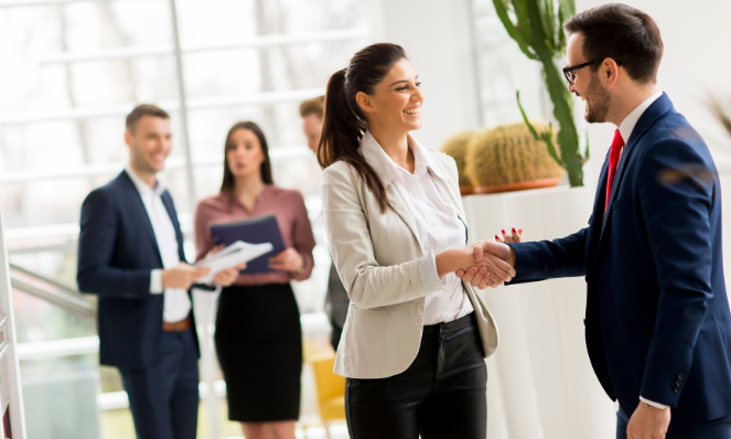 Business people smiling and shaking hands.
