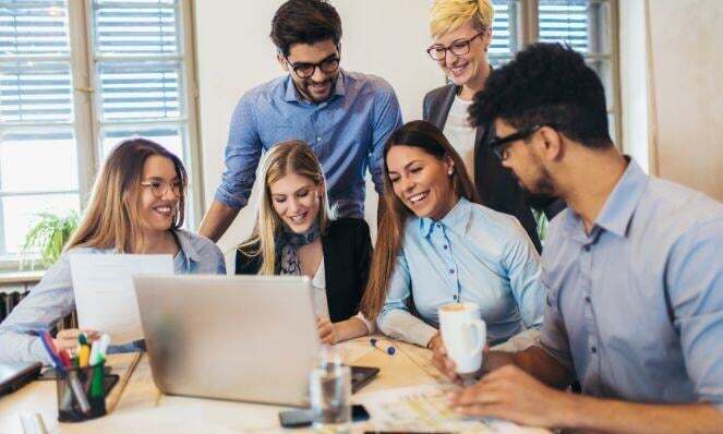 People working together while looking at one laptop.