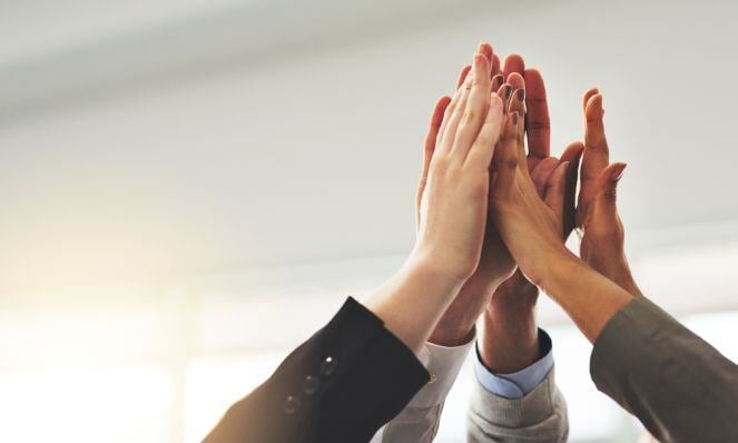 Coworkers celebrating and doing high five.