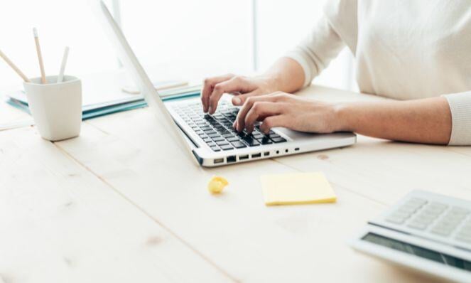 Person's hands typing on a laptop.