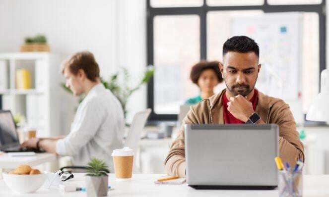 Three workmates working on their laptops.