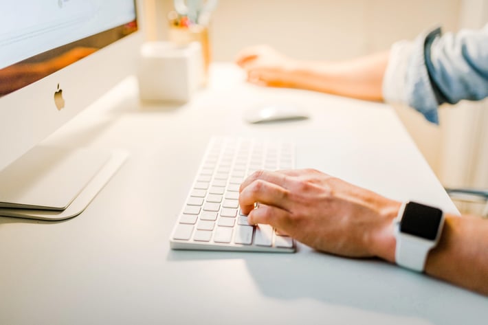 A person typing on her computer keyboard.