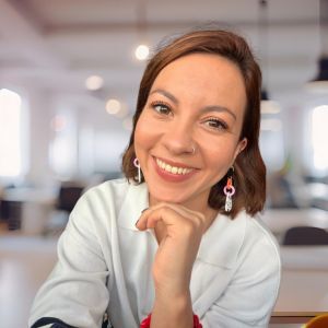 Margarita Huertas is smiling at the camera with her hand under her chin.